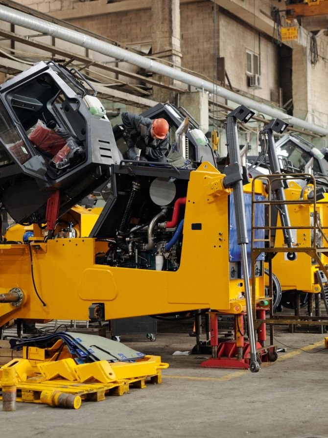 Male workers of industrial plant or repairmen checking efficiency of machines